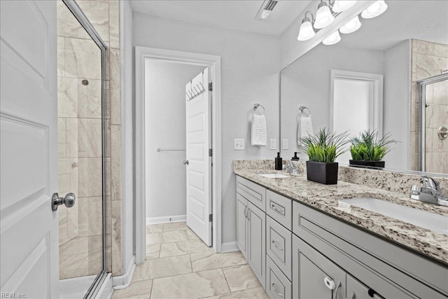 bathroom with visible vents, a sink, double vanity, and a shower stall