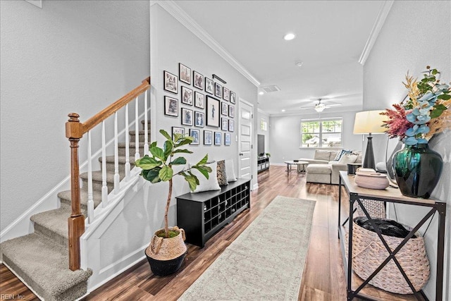 corridor with recessed lighting, ornamental molding, wood finished floors, and stairway