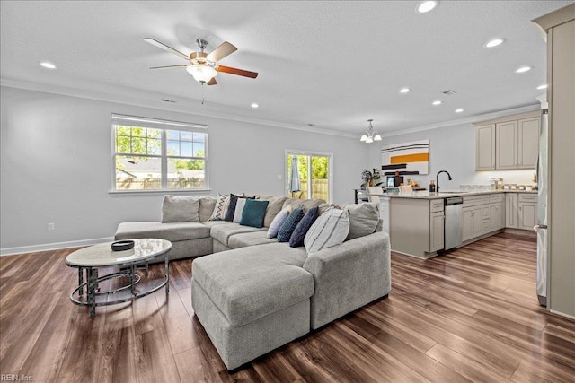 living room featuring crown molding, recessed lighting, ceiling fan with notable chandelier, and dark wood-style floors