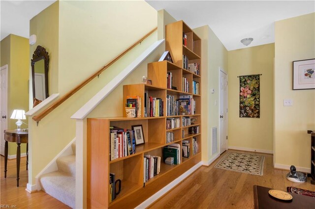 hall with stairs, wood finished floors, and baseboards