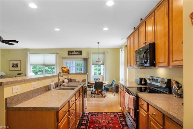 kitchen with recessed lighting, stainless steel appliances, a sink, and brown cabinetry