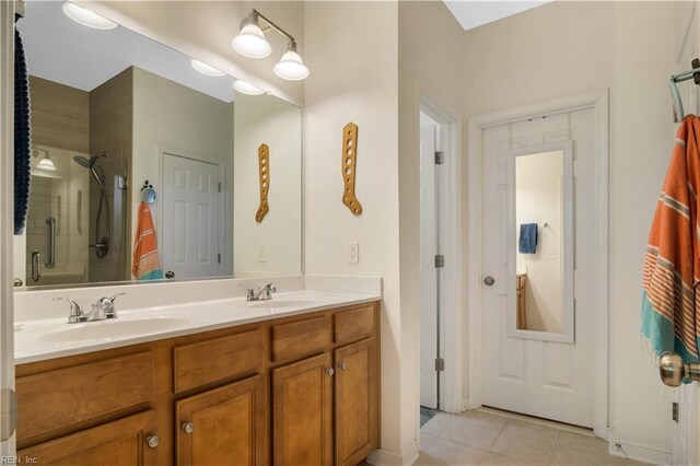 bathroom featuring tile patterned floors, a sink, a shower stall, and double vanity