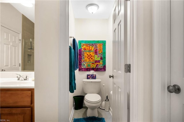bathroom with tile patterned flooring, toilet, vanity, baseboards, and walk in shower
