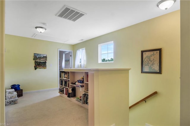 carpeted office with attic access, visible vents, and baseboards