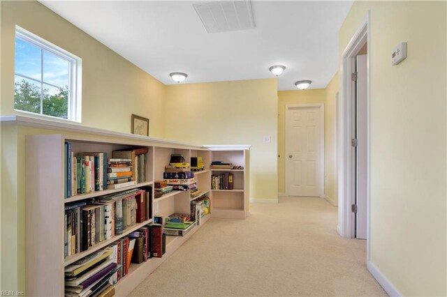 hallway with baseboards, visible vents, and carpet floors