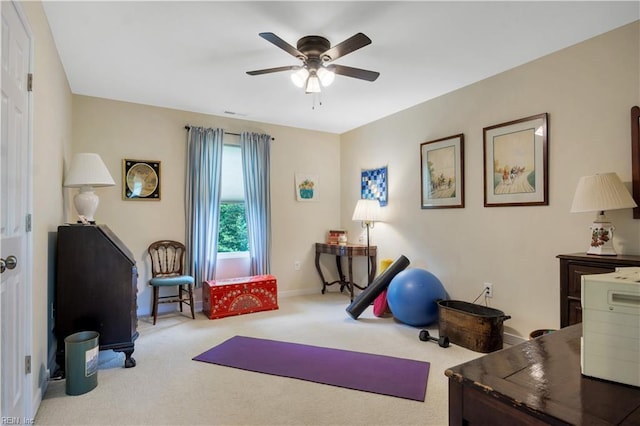 exercise area with ceiling fan, baseboards, and carpet flooring