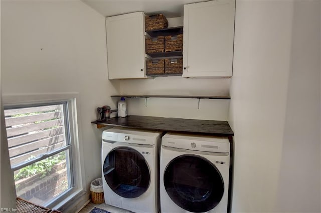 washroom featuring a wealth of natural light, cabinet space, and washing machine and dryer