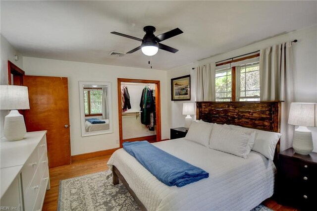 bedroom with light wood-style floors, visible vents, a closet, baseboards, and a ceiling fan