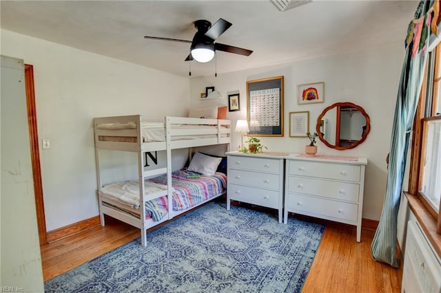 bedroom with light wood finished floors, ceiling fan, and baseboards