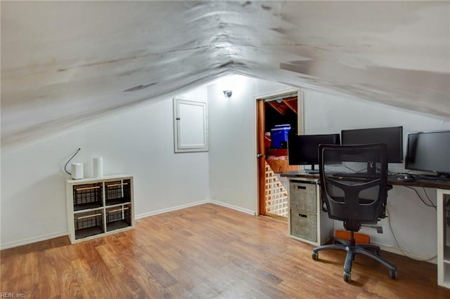 office featuring wood finished floors, vaulted ceiling, and baseboards