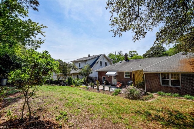 rear view of property featuring fence, a yard, a patio, and brick siding