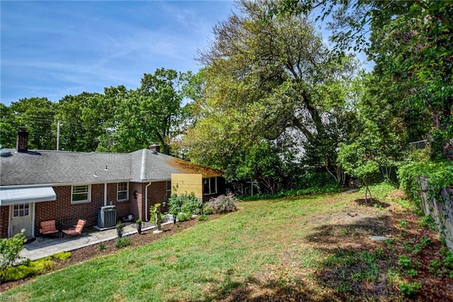 view of yard featuring a patio, fence, and central AC unit