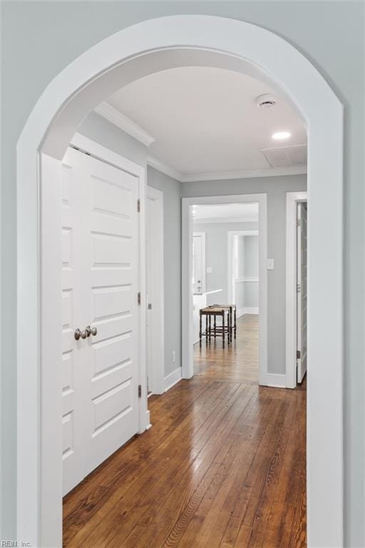 entryway with crown molding, arched walkways, hardwood / wood-style floors, and baseboards