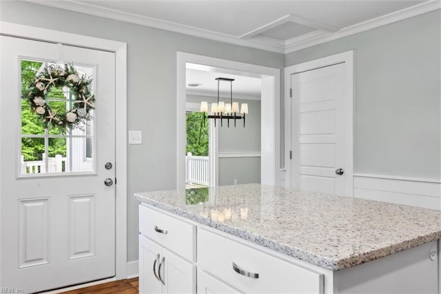 doorway with crown molding, a notable chandelier, wood finished floors, and a healthy amount of sunlight