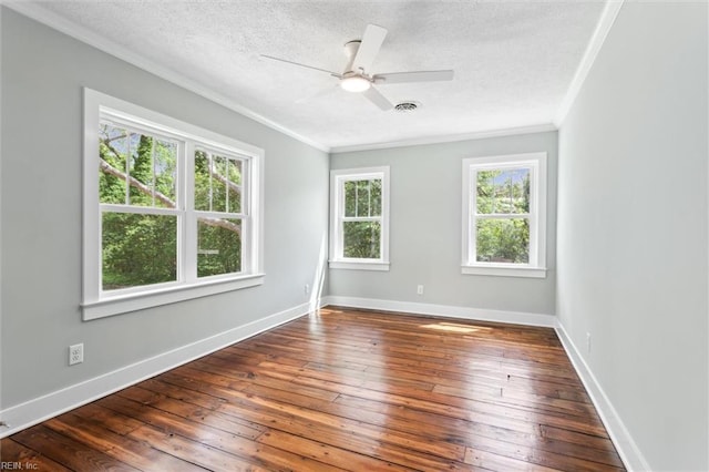 empty room with crown molding, a textured ceiling, visible vents, and hardwood / wood-style flooring