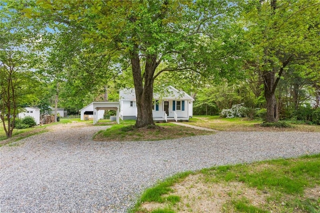 bungalow-style home with driveway, a carport, and a porch