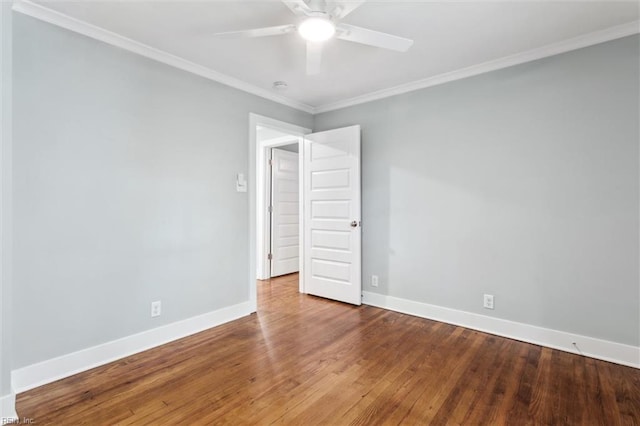 empty room featuring wood finished floors, a ceiling fan, crown molding, and baseboards