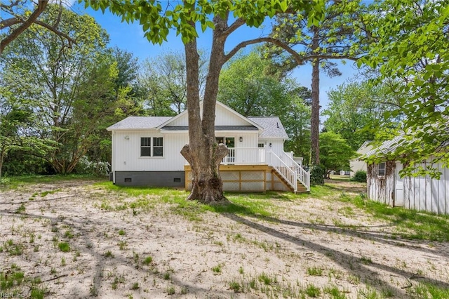 back of property featuring stairs and crawl space
