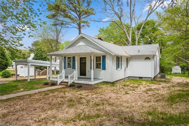view of front of house featuring central air condition unit, crawl space, an outbuilding, covered porch, and a shed