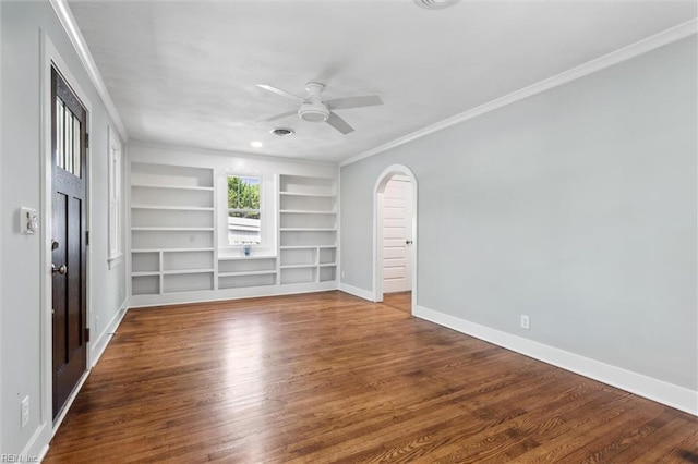 unfurnished room with crown molding, ceiling fan, baseboards, arched walkways, and built in features