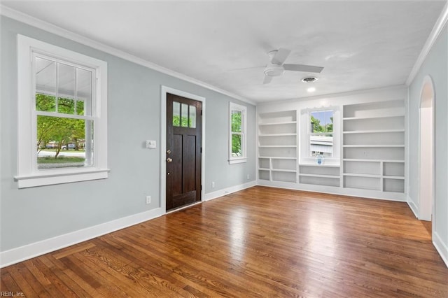 foyer entrance featuring ornamental molding, wood finished floors, and baseboards