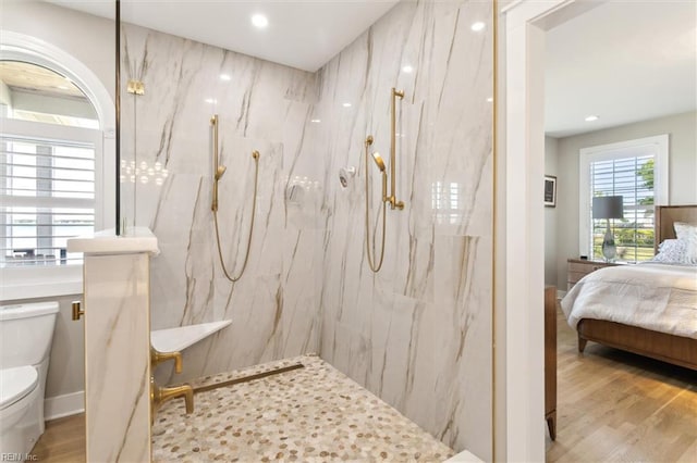 bathroom with wood finished floors, toilet, recessed lighting, connected bathroom, and a marble finish shower