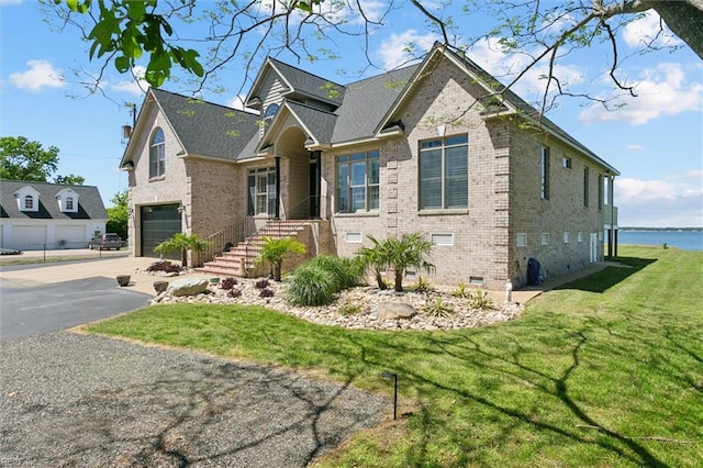 view of front of house with a garage, aphalt driveway, a front lawn, and brick siding