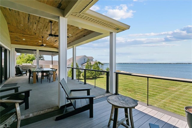 deck with outdoor dining area, a water view, and ceiling fan