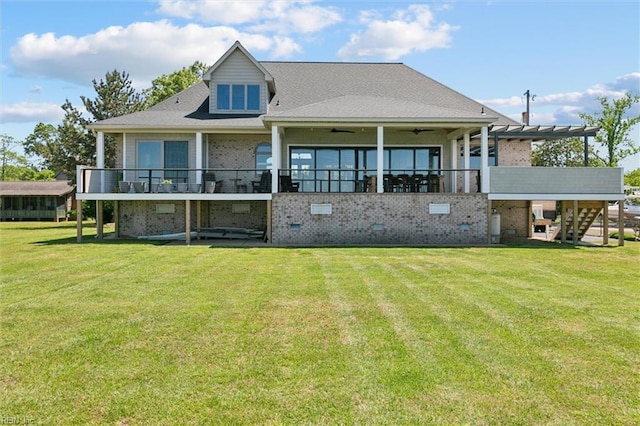back of house featuring stairs, ceiling fan, a yard, and brick siding