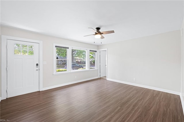 unfurnished living room with a ceiling fan, baseboards, and dark wood-style flooring