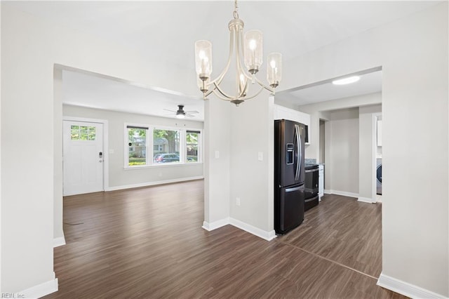 kitchen featuring dark wood-style flooring, baseboards, electric range oven, white cabinetry, and black fridge