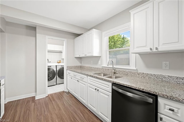 kitchen featuring white cabinets, a sink, light wood-type flooring, separate washer and dryer, and dishwashing machine