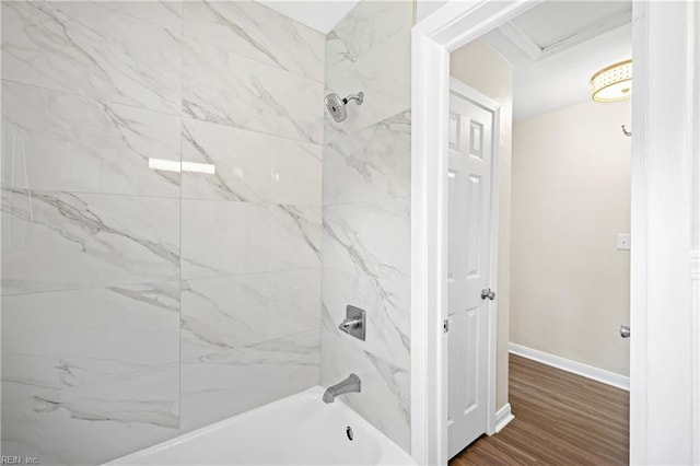 full bath featuring baseboards, wood finished floors, and shower / tub combination