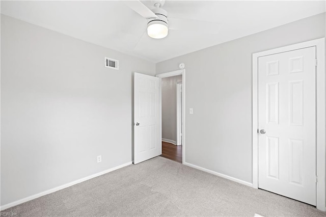 unfurnished bedroom featuring visible vents, a ceiling fan, baseboards, and carpet
