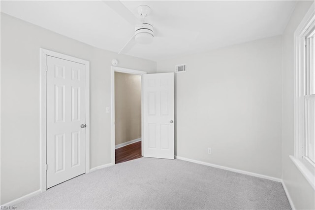 unfurnished bedroom featuring carpet floors, visible vents, and baseboards