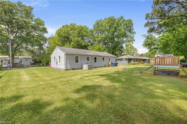 back of property featuring central air condition unit, crawl space, a yard, and a playground