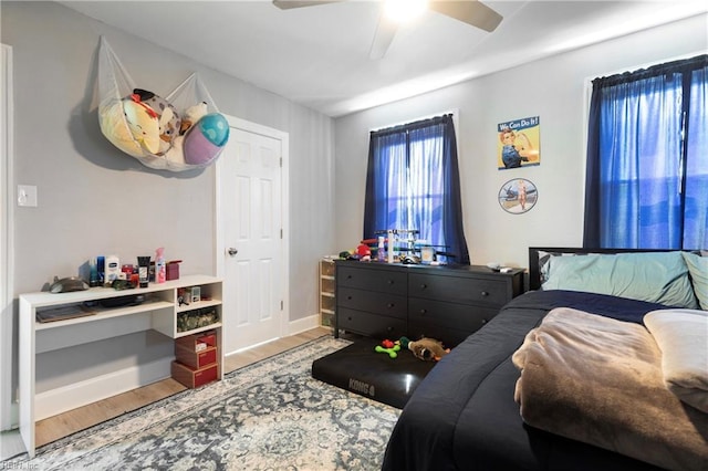 bedroom with baseboards, wood finished floors, and a ceiling fan