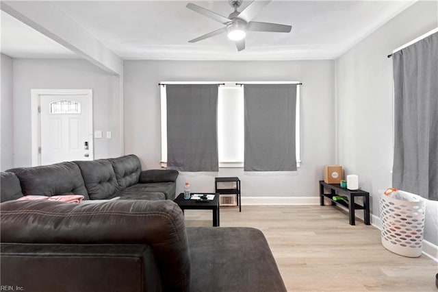living room featuring ceiling fan, light wood-type flooring, and baseboards