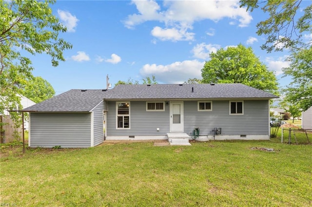 back of property featuring fence, a yard, and crawl space