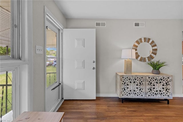 entrance foyer with visible vents, a wealth of natural light, and wood finished floors