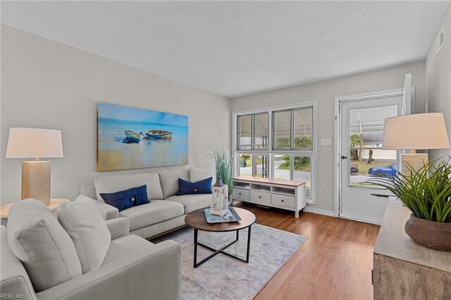 living area with baseboards and wood finished floors