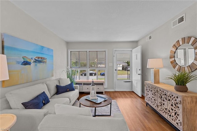 living area featuring wood finished floors, visible vents, and baseboards