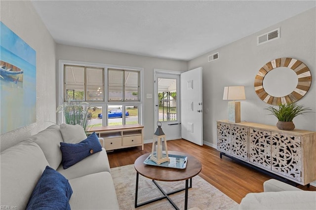 living room with visible vents, wood finished floors, and baseboards