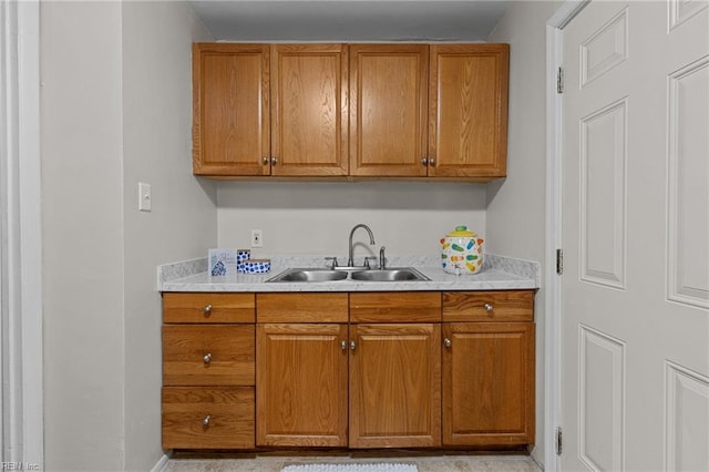 kitchen featuring a sink, brown cabinetry, and light countertops