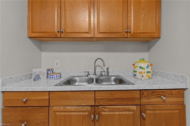 kitchen featuring a sink, brown cabinetry, and light countertops