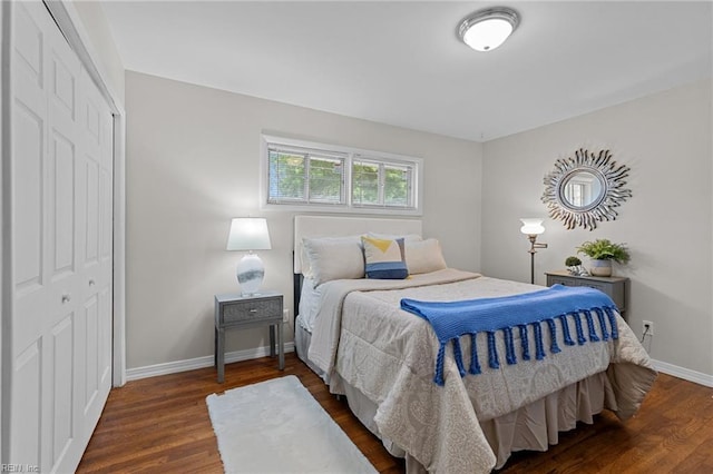 bedroom with wood finished floors, baseboards, and a closet