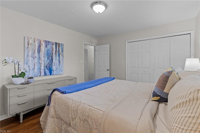 bedroom with dark wood-type flooring, baseboards, and a closet