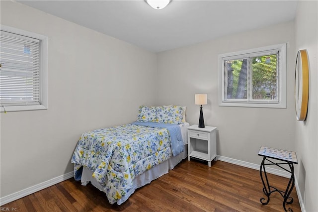 bedroom with wood finished floors and baseboards