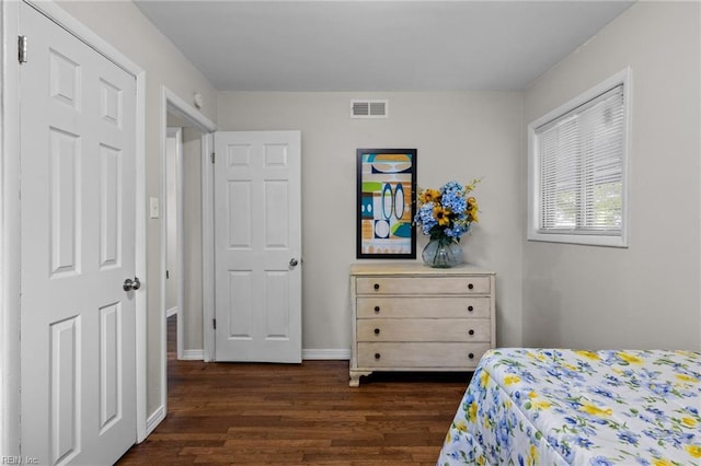 bedroom with dark wood-style flooring, baseboards, and visible vents