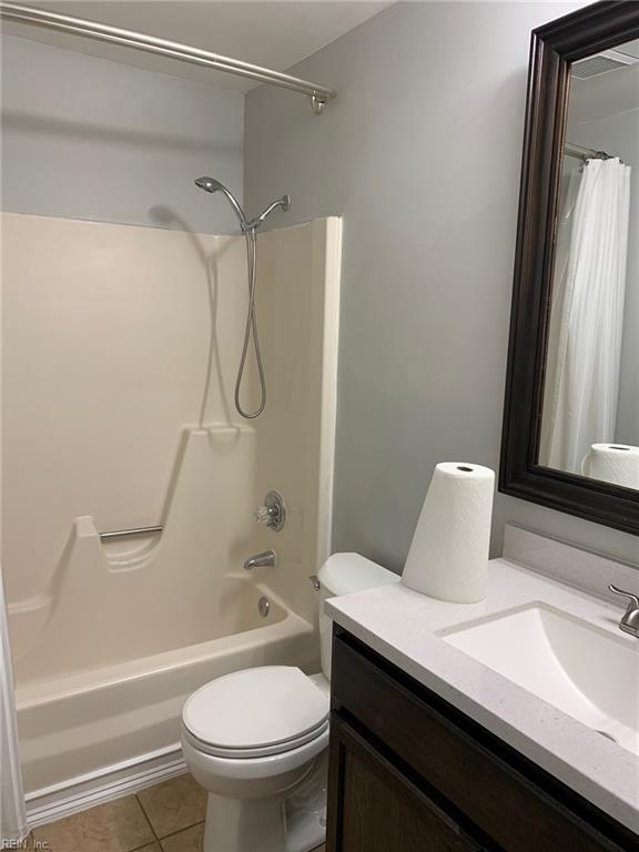 bathroom with vanity, tile patterned flooring, toilet, and shower / tub combo with curtain
